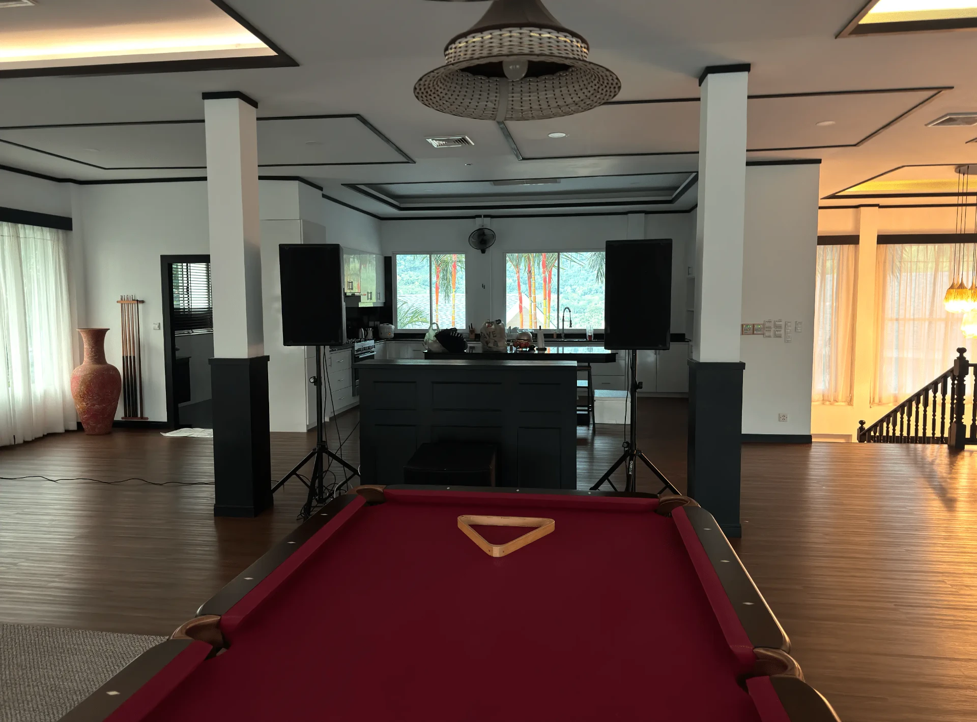 Indoor villa setup in Phuket with two speakers on stands beside a pool table